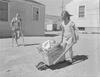 Girls playing in front of house with homemade baby buggy Girls playing in front of house with homemade baby buggy